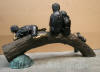 Three kids on log with squirrel bronze statue