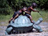 Two kids riding turtle bronze statue